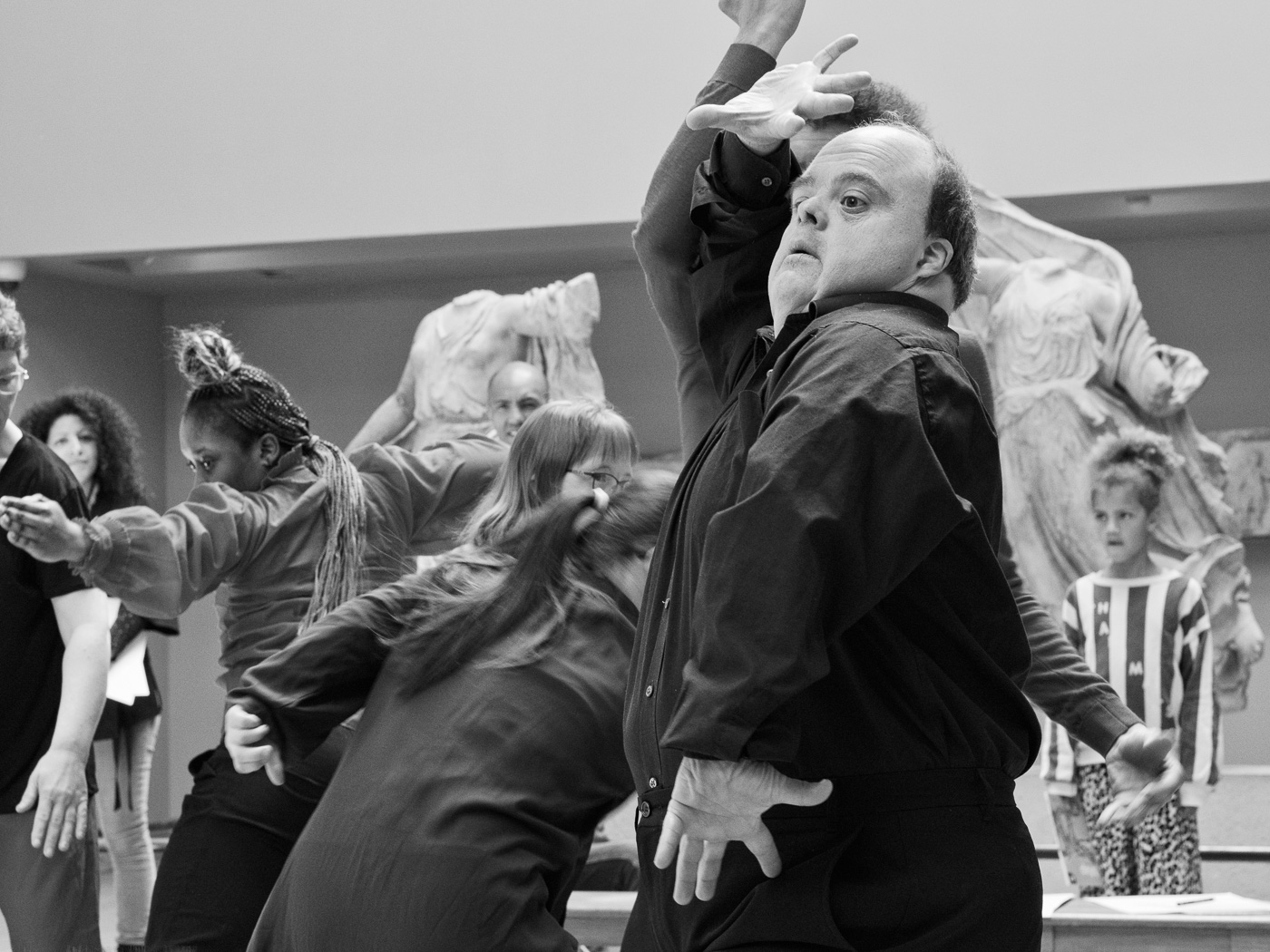 Black and white photo of Graham expressively using his arms and hands dancing at the British Museum